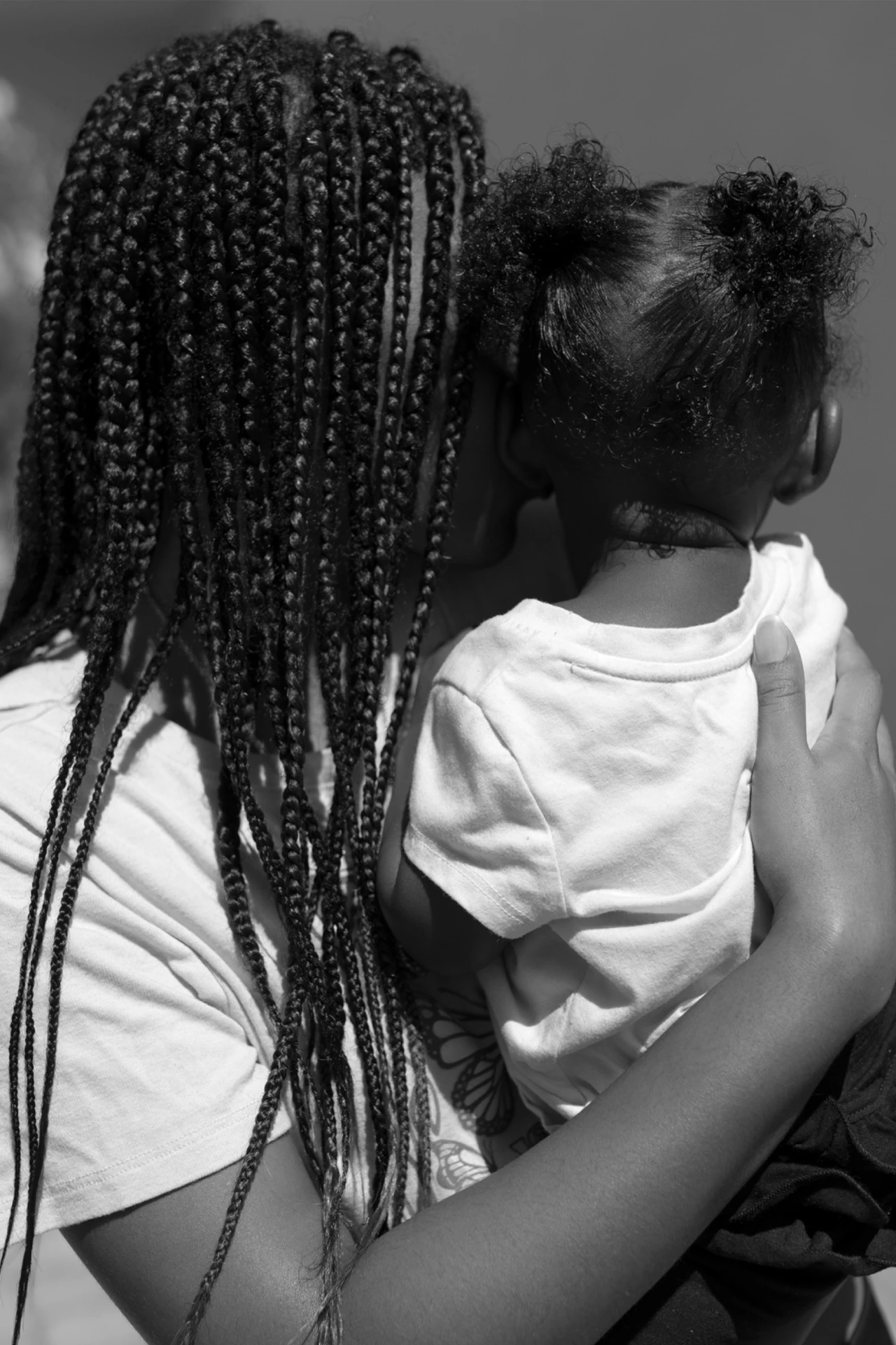 A Haitian mother holds her young daughter in her arms.