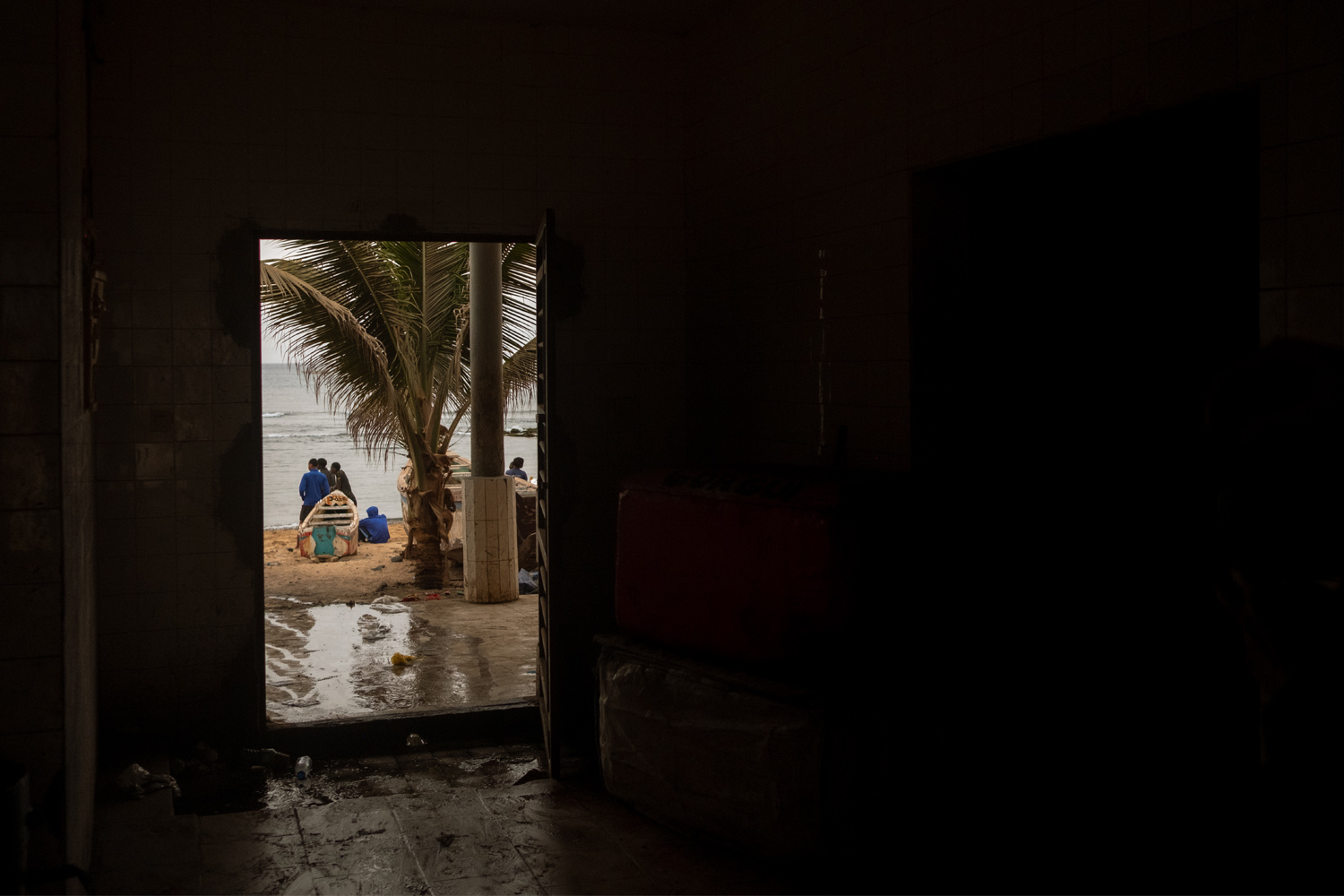 Fishermen sit outside on the shore of Oakam, evaluating the day's catch. 