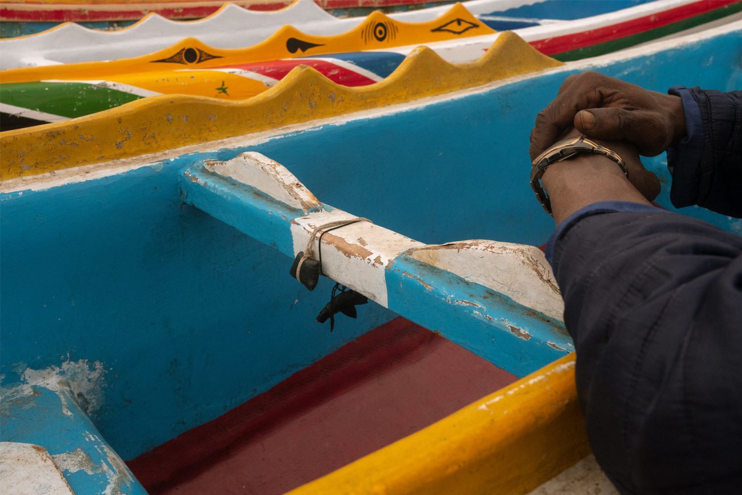 A local fisherman explains that each boat carries familial sentiment and African juju in Oakam, Senegal. 