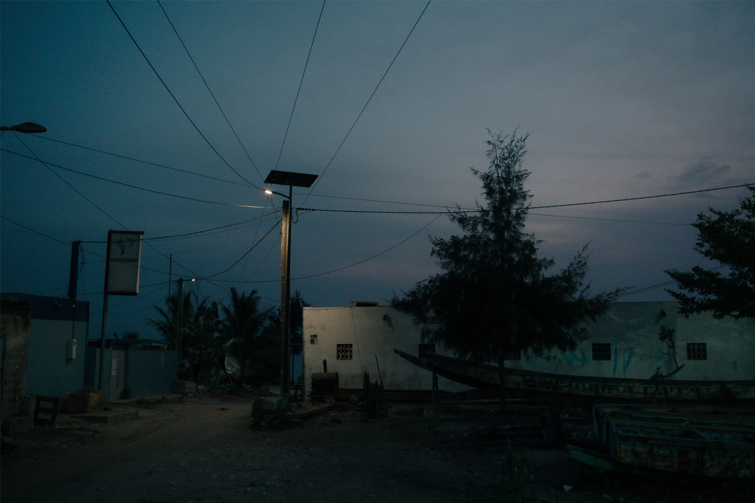 Dusk falls in Oakam, Senegal, a streetlight illuminating the path. 